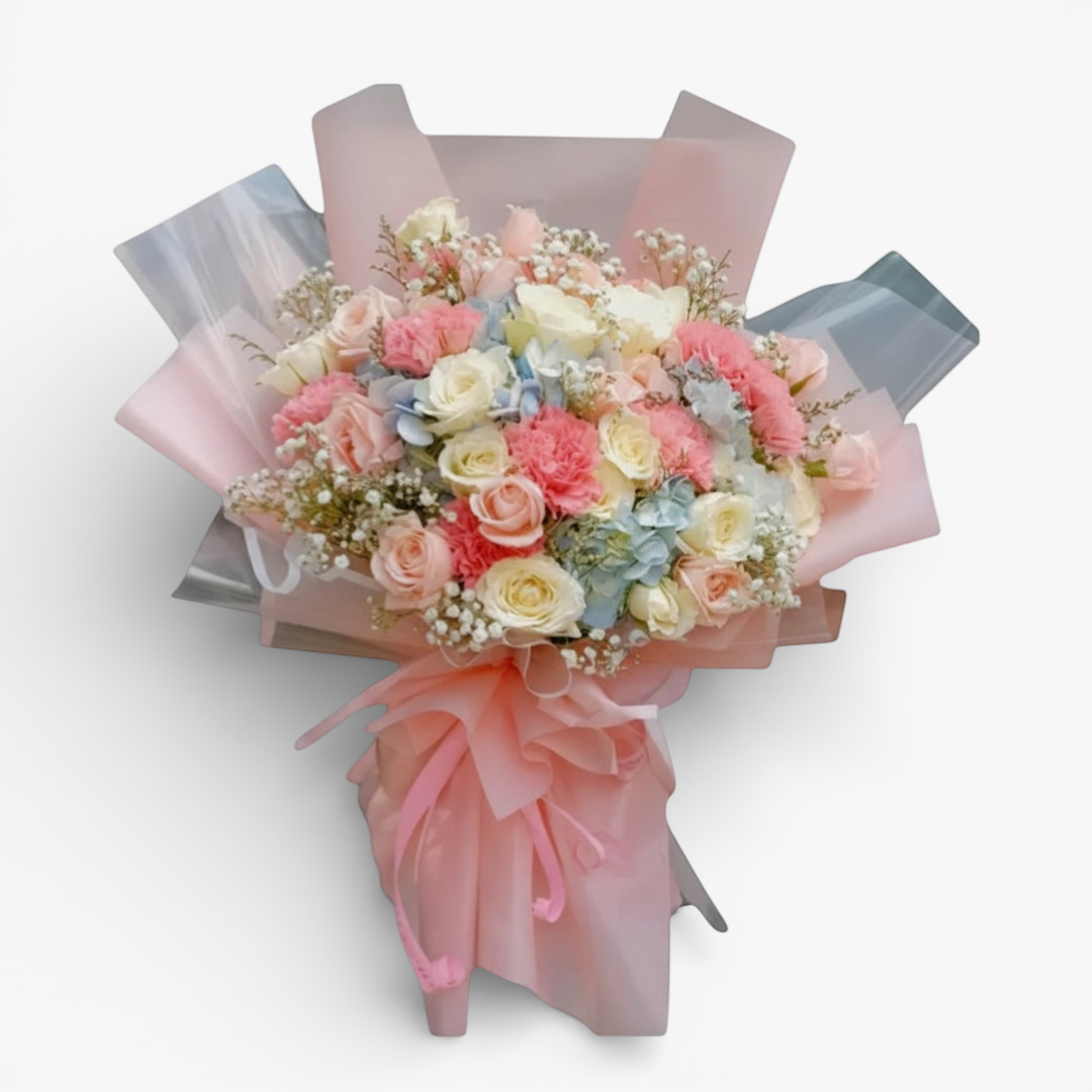 The Flowercart Pastel Dreams bouquet with pink roses, white roses, pink carnations, blue hydrangea, and baby's breath.