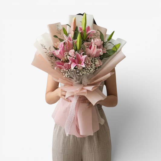 The Flowercart Star Lily bouquet features pink Stargazer lilies, pink roses, baby's breath, and misty blue fillers, elegantly wrapped.