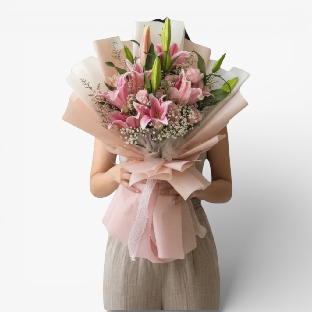 The Flowercart Star Lily bouquet features pink Stargazer lilies, pink roses, baby's breath, and misty blue fillers, elegantly wrapped.