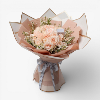 The Flowercart 50 pink roses bouquet with baby's breath, elegantly wrapped in blush pink paper and tied with a white ribbon.