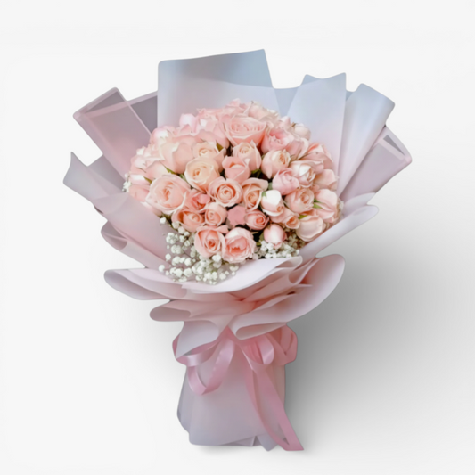 The Flowercart Mardigrass bouquet with 50 premium pink roses and baby's breath, wrapped in pink and white paper with a pink ribbon.