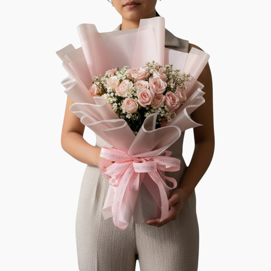 The Flowercart's California Dreaming bouquet: 24 soft pink roses with baby's breath, wrapped in pink paper and tied with a pink ribbon.
