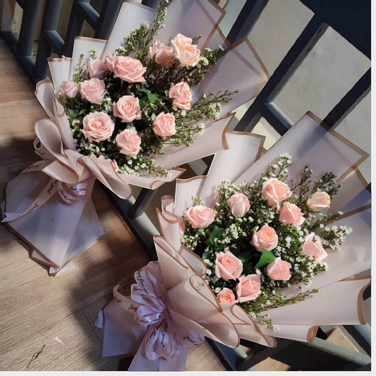 The Flowercart's Autumn Morning bouquet: 12 pink roses with white fillers, elegantly wrapped in pale pink paper and ribbon.