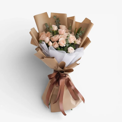 The Flowercart Terra Cotta bouquet: 24 soft pink roses and eucalyptus, wrapped in brown paper with a satin ribbon.