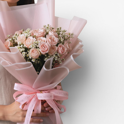 The Flowercart's California Dreaming bouquet: 24 soft pink roses with baby's breath, wrapped in pink paper with a pink ribbon.