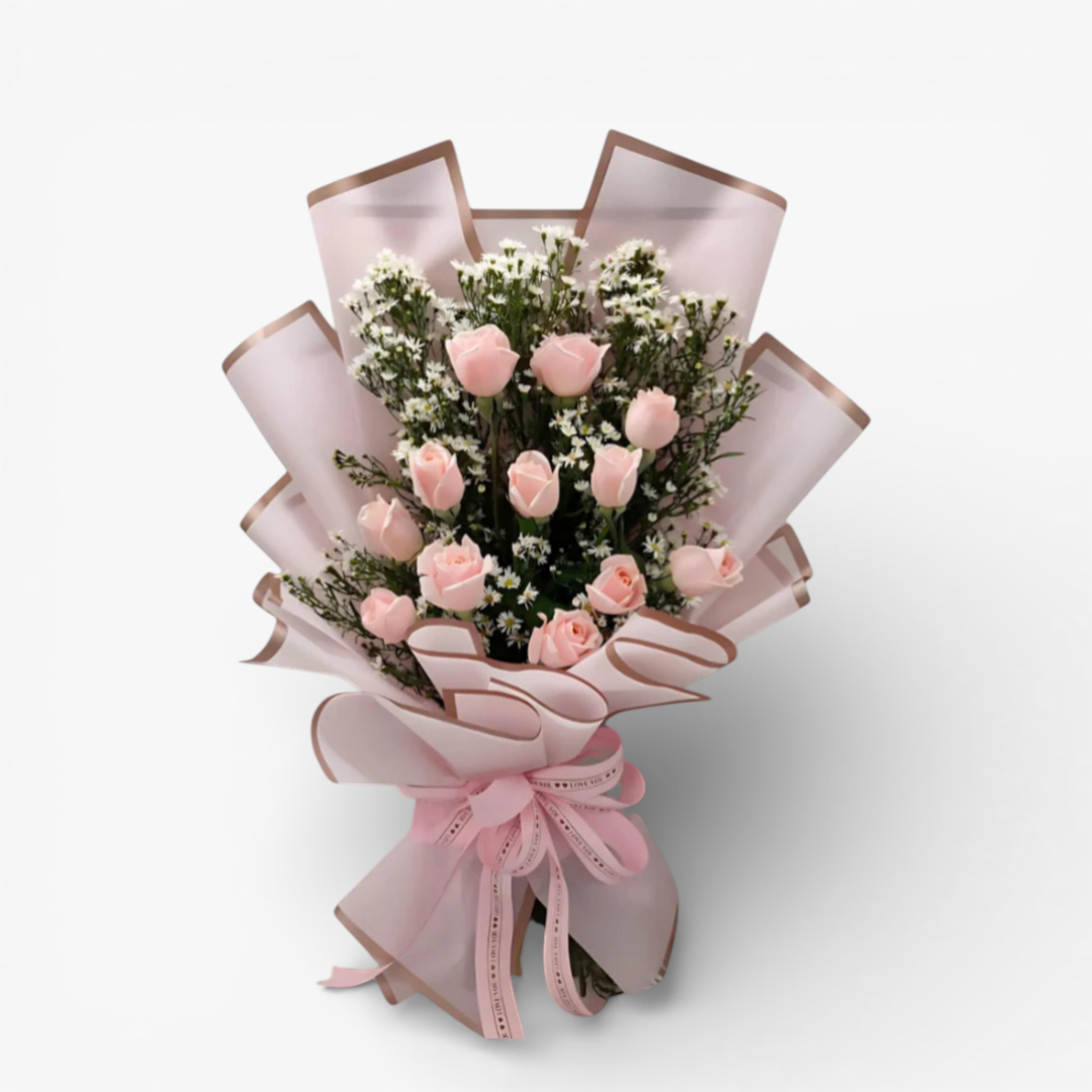 The Flowercart bouquet of 12 pink roses with white fillers, wrapped in pink paper and tied with a pink ribbon.
