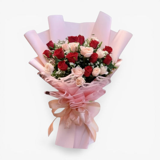 The Flowercart's Majestic Bouquet: 24 red and pink roses with baby's breath and greenery, wrapped in pink paper with a gold accent and ribbon.