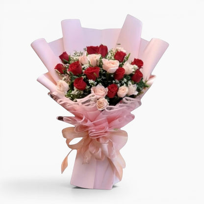 The Flowercart's Majestic Bouquet: 24 red and pink roses with baby's breath and greenery, wrapped in pink paper with a gold accent and ribbon.