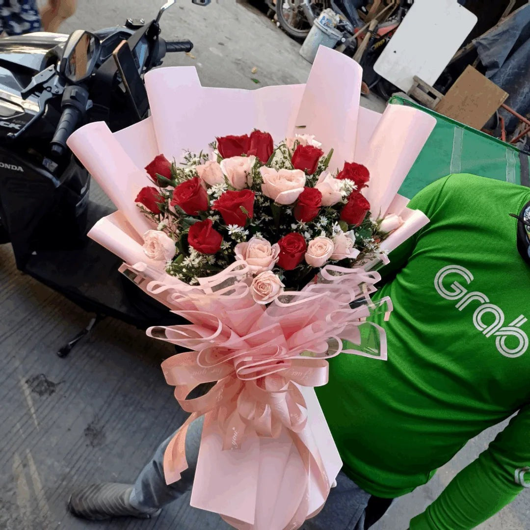 The Flowercart's Majestic Bouquet: 24 red and pink roses with baby's breath, elegantly wrapped in pink paper and ribbon.