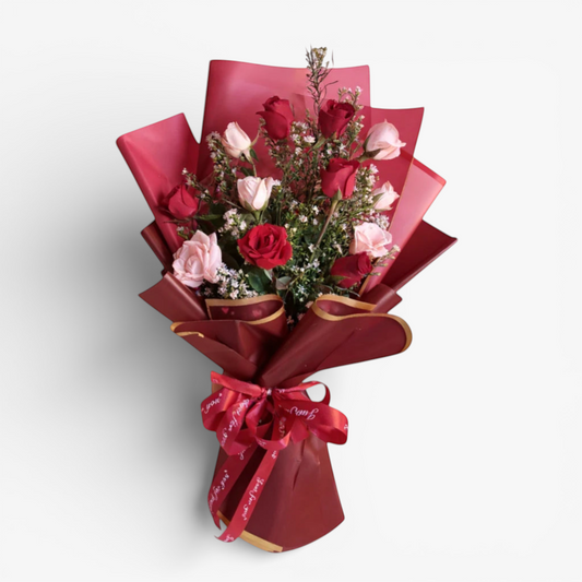 The Flowercart Sweet Heart Bouquet: 12 red and pink roses with baby's breath, wrapped in red paper and ribbon.