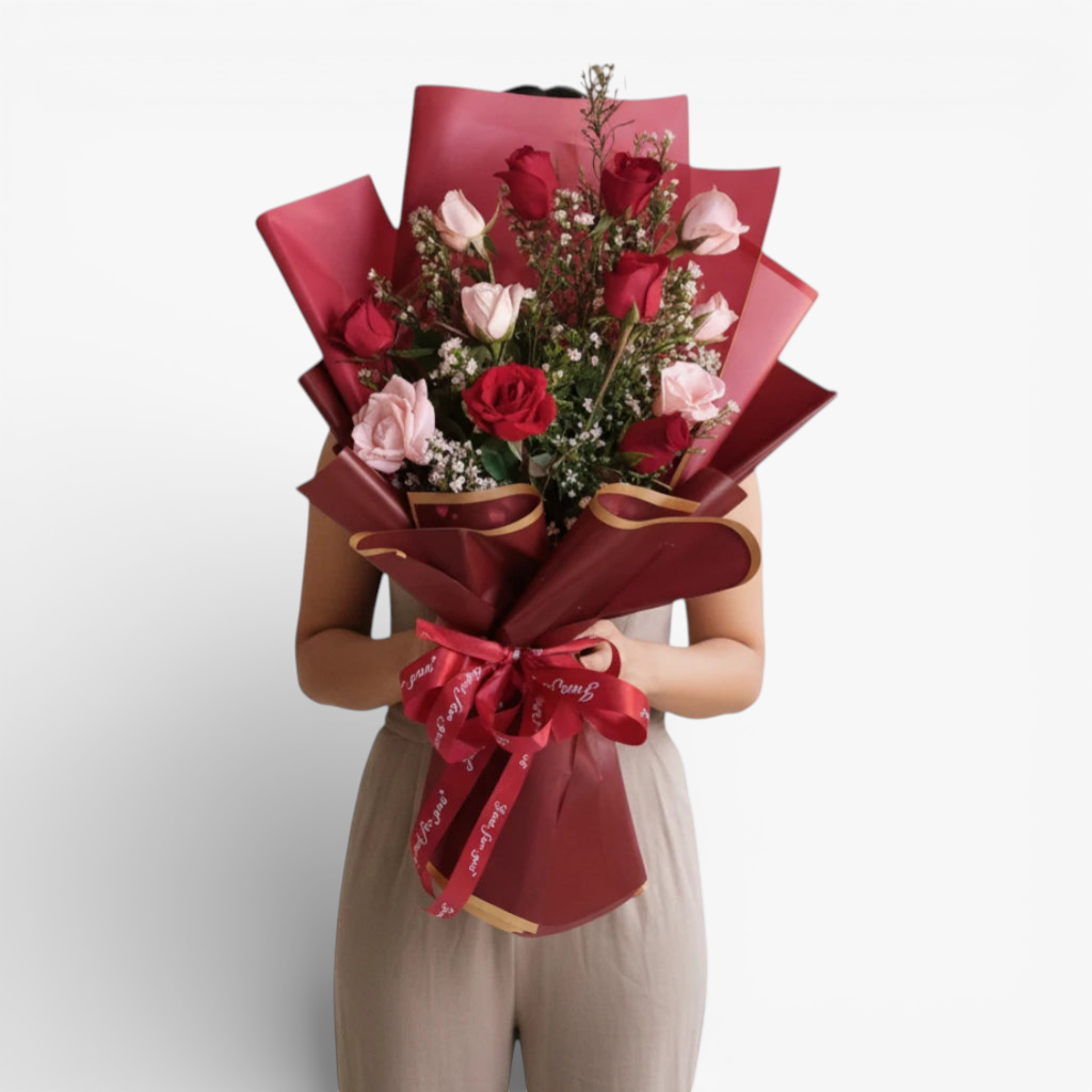 The Flowercart Sweet Heart Bouquet: 12 red and pink roses with baby's breath, wrapped in red paper and tied with a 'Just for you' ribbon.