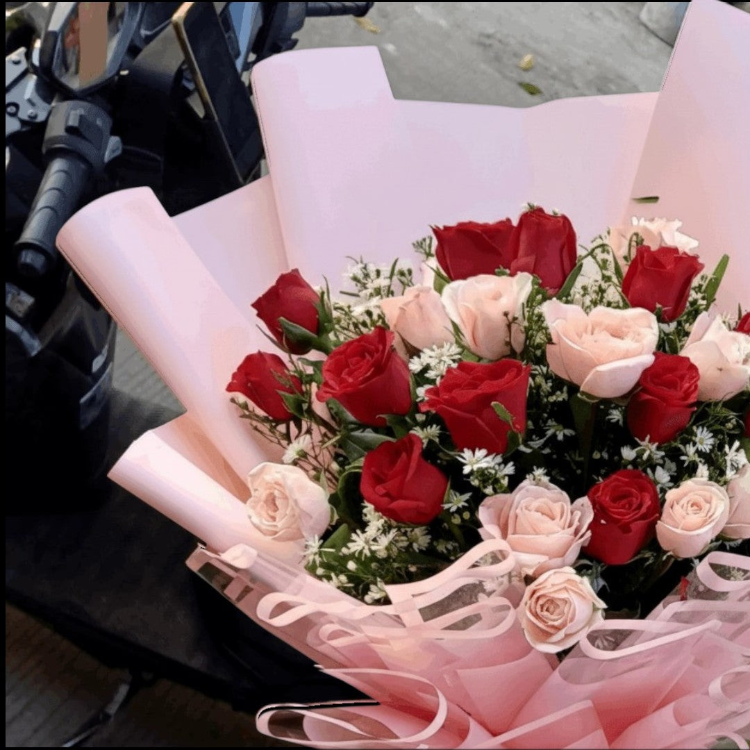 The Flowercart Majestic Bouquet: 24 red and pink roses with baby's breath and greenery, perfect for anniversaries.
