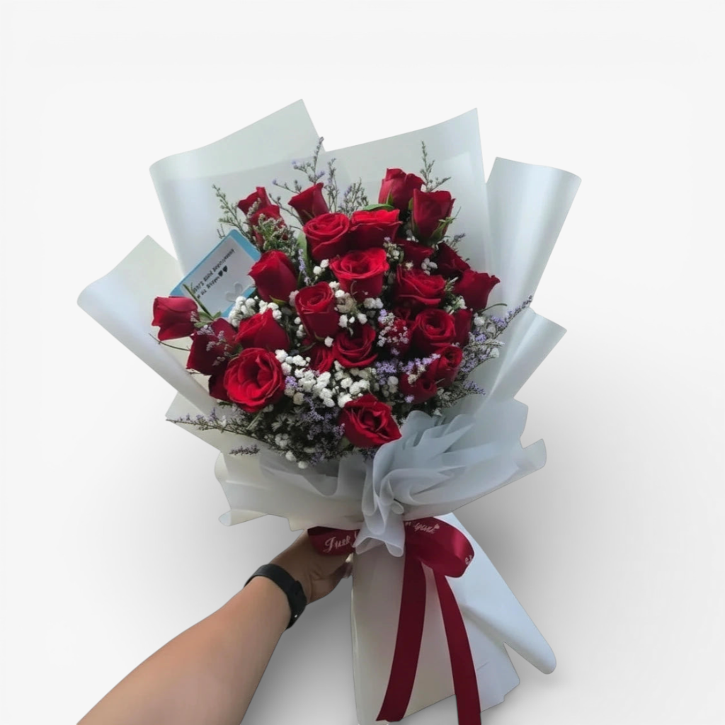 The Flowercart's Fallin For You bouquet: 24 vibrant red roses with baby's breath and misty blue fillers, elegantly wrapped.
