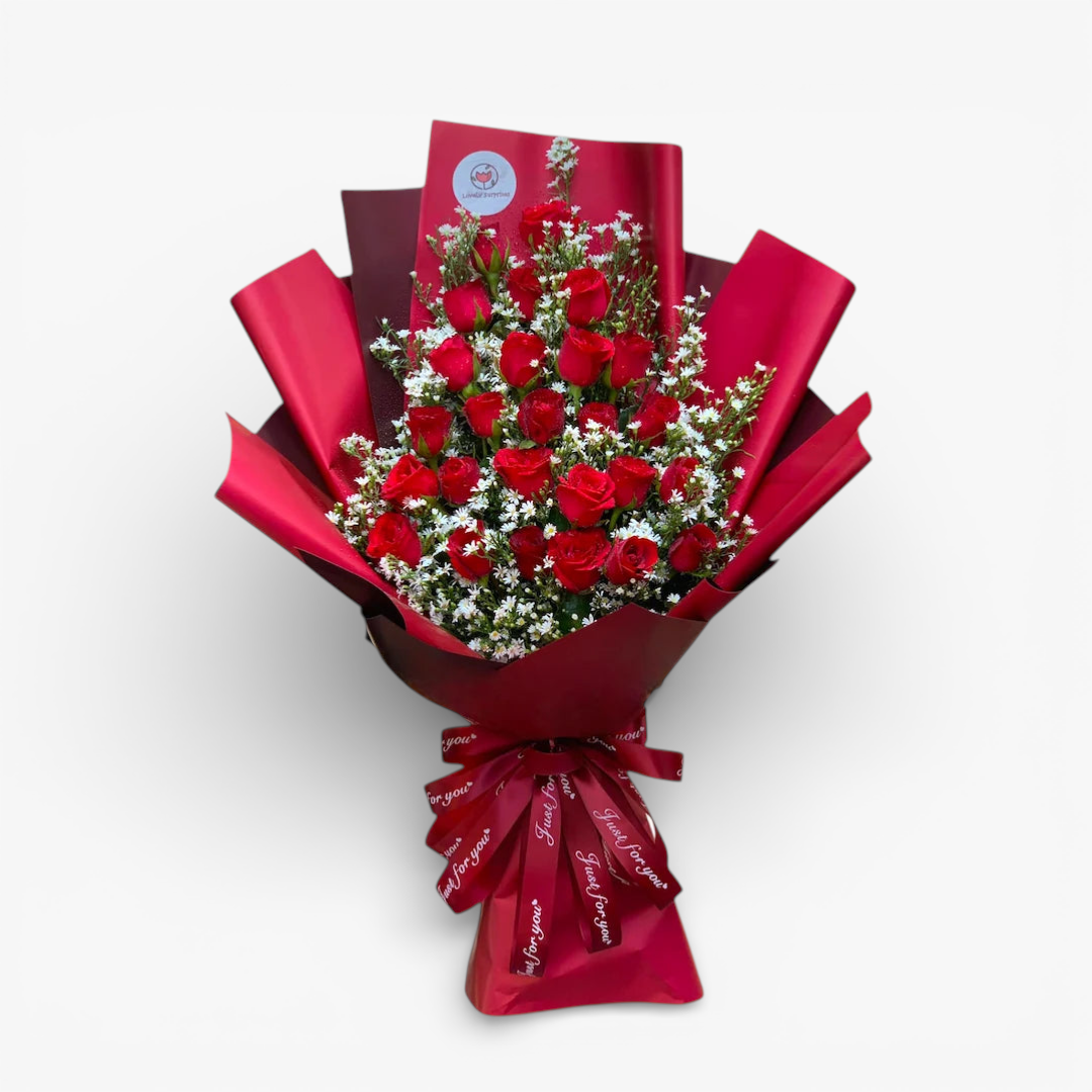 The Flowercart Valley Scent bouquet: 24 red roses with baby's breath, wrapped in red paper and ribbon.