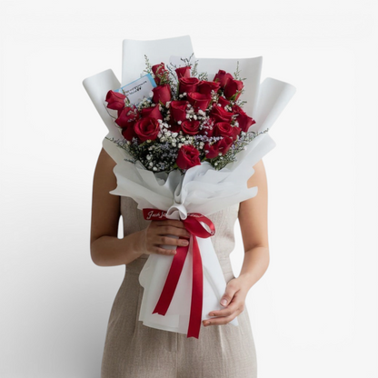 The Flowercart Fallin For You bouquet: 24 red roses with baby's breath and misty blue fillers, elegantly wrapped.