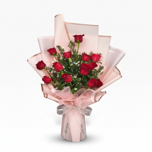The Flowercart Sweet Success bouquet: 12 red roses with delicate filler flowers, wrapped in pink and cream paper with a satin ribbon. Ideal for congratulations.