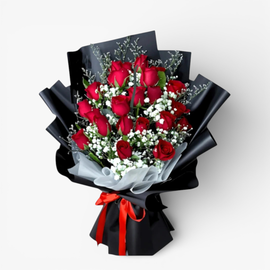 The Flowercart Luxe Noir bouquet: 24 red roses with white fillers, wrapped in black paper and tied with a red ribbon.